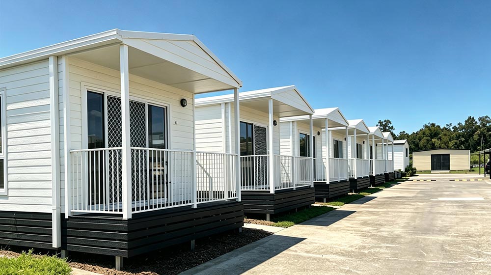Series of white foldable houses with small balconies, set against a clear blue sky, showcasing modern compact living solutions by Deepblue.