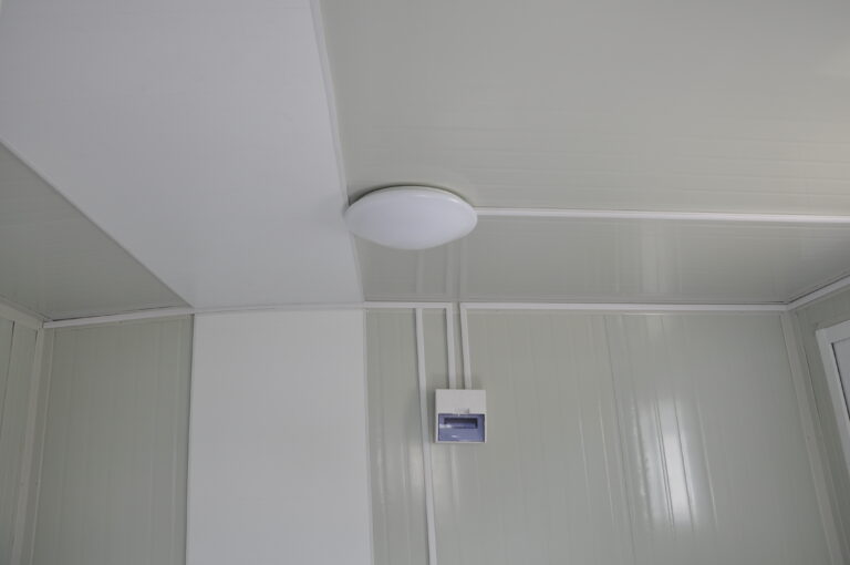 Apparecchio di illuminazione a soffitto in un moderno container o cabina isolata, che mette in mostra un design interno efficiente ed elegante per spazi modulari o portatili.
