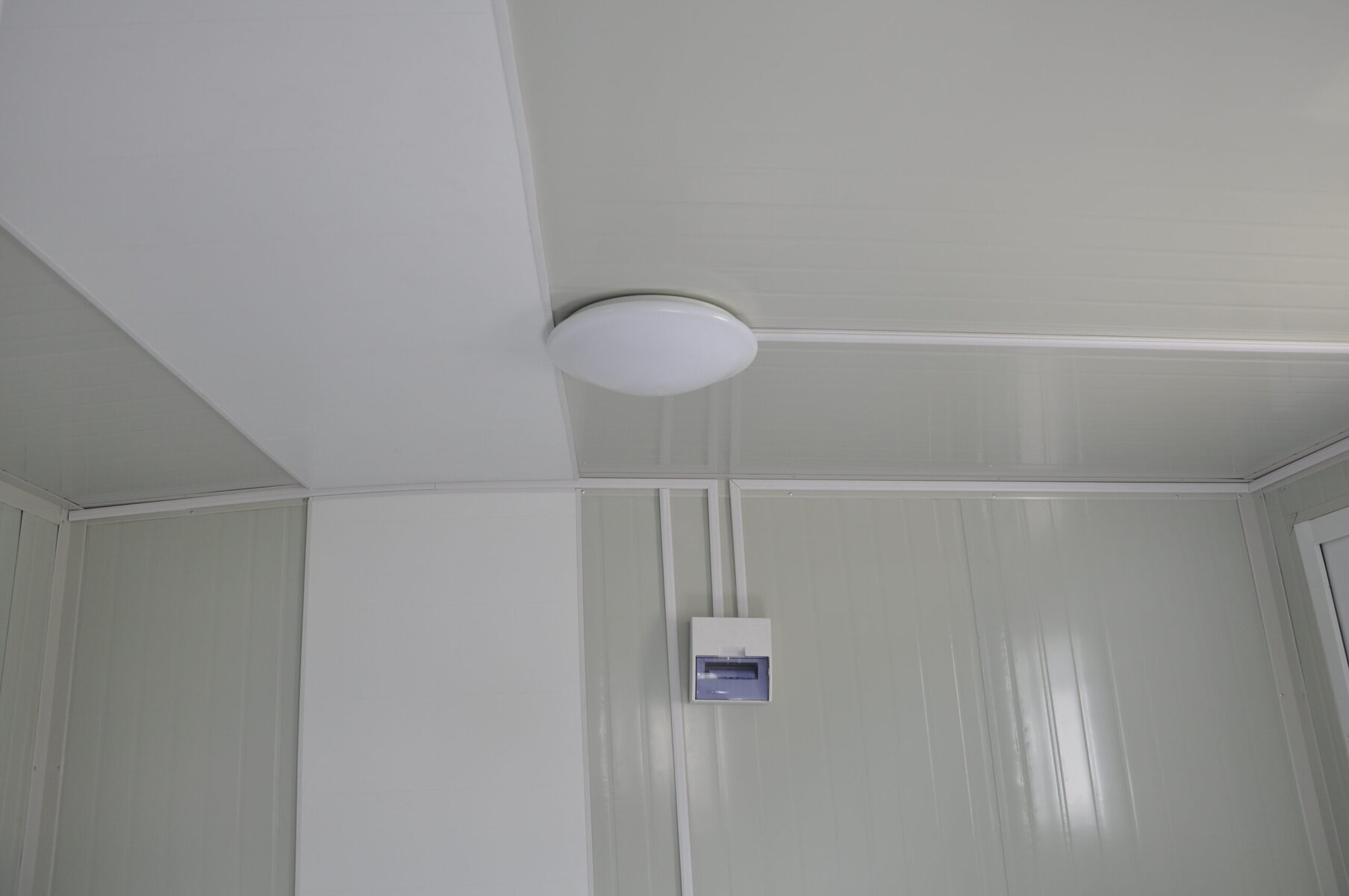Ceiling lighting fixture in a modern insulated container or cabin, showcasing efficient and sleek interior design for modular or portable spaces.