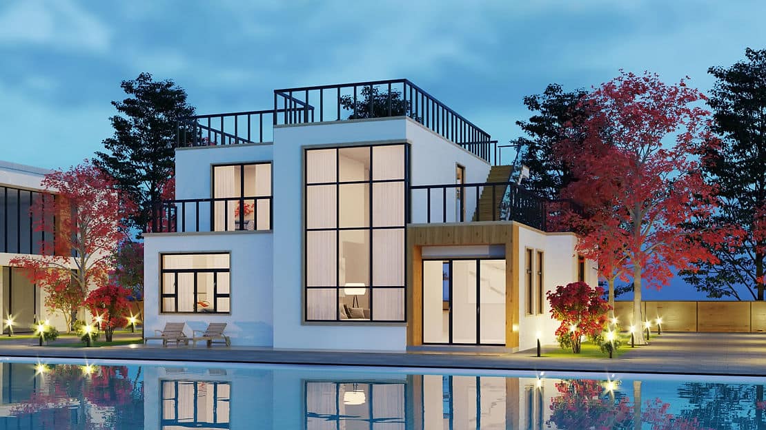White two-story house with rooftop terrace and large windows, reflected in a pool at dusk among trees.