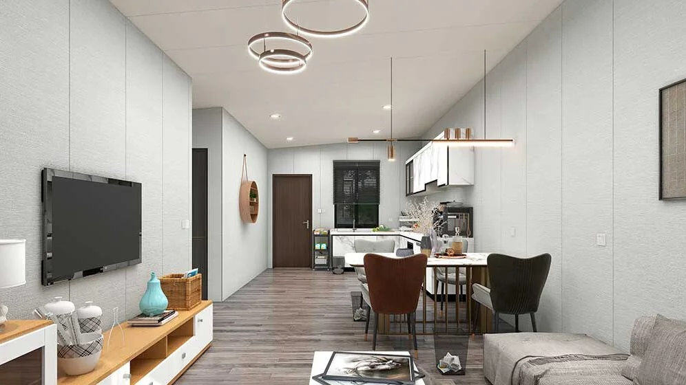 Open-plan living/dining area with modern furnishings, wall TV, kitchenette, and minimalist neutral-toned decor.