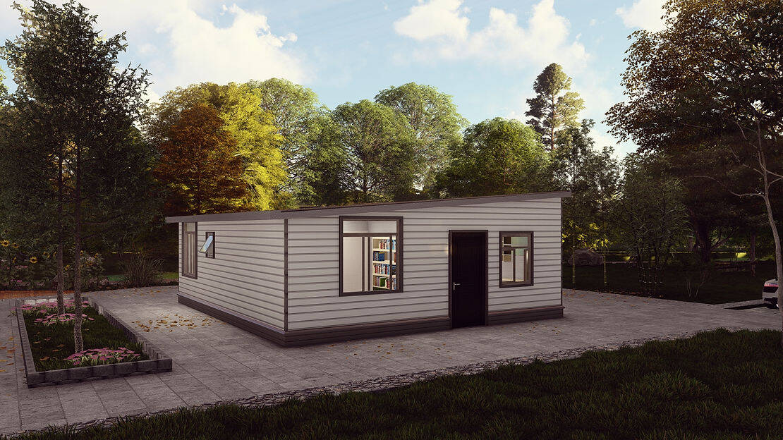 A small modern house with white and gray siding sits on pavement, surrounded by trees and greenery.