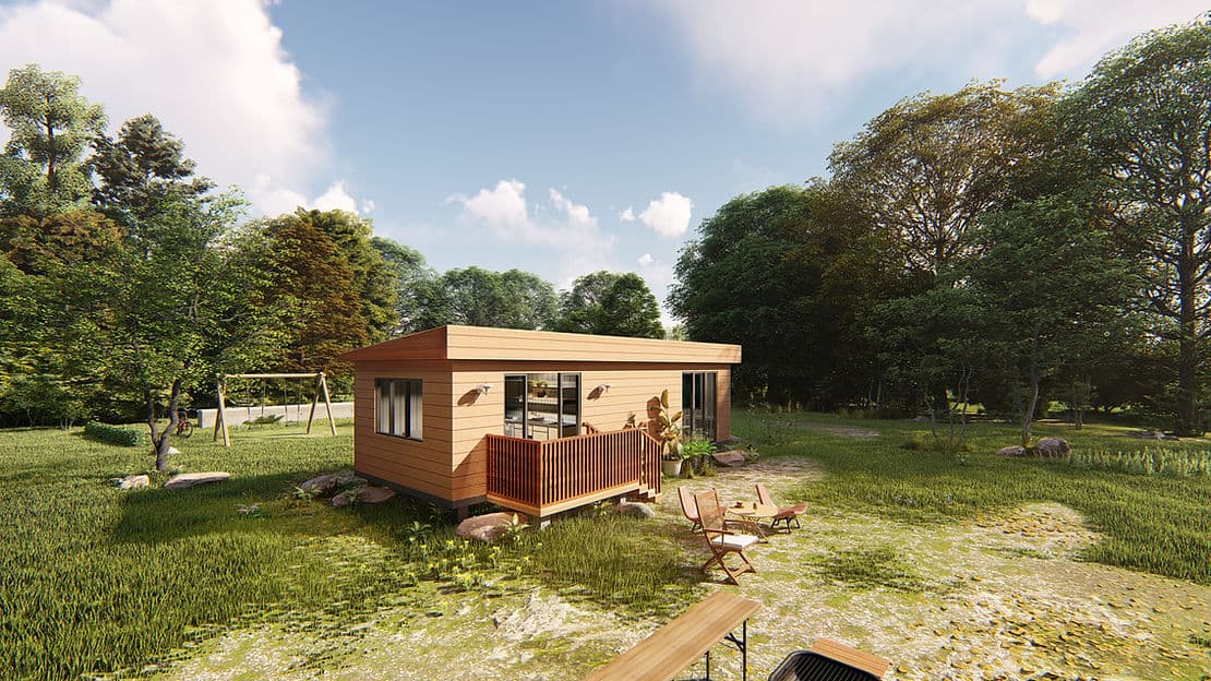 Modern cabin with wooden deck in a grassy clearing, surrounded by trees, outdoor chairs, and a swing set.