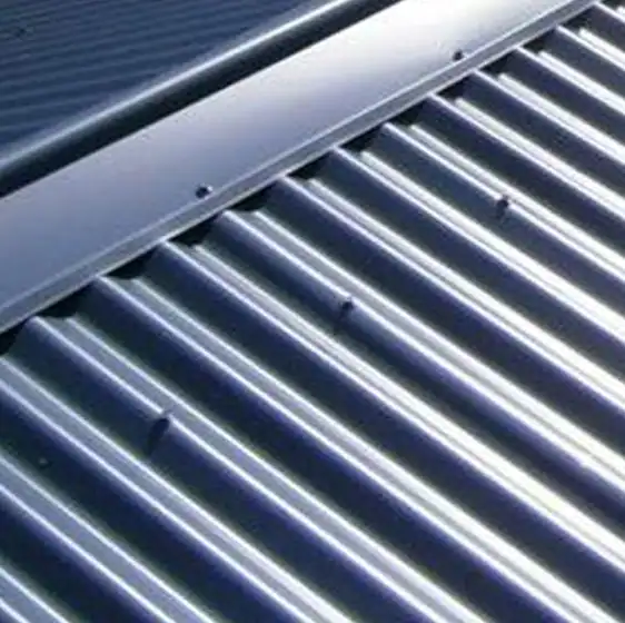 Close-up of a corrugated metal roof with uniform ridges and metal flashing along the top edge.