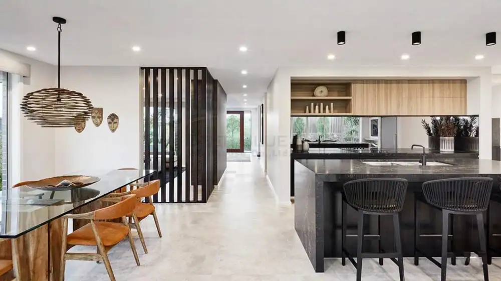 Open-plan kitchen and dining area with wood and black details, marble island, wooden table, and slatted partition.