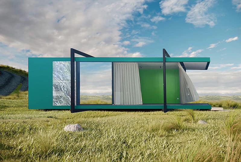 Green rectangular modular home with large glass doors, white curtains, and metal frame on grass under partly cloudy sky.