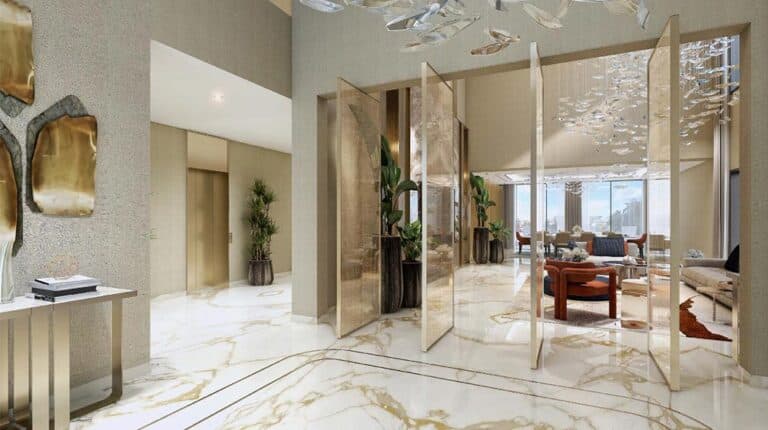 Modern lobby with marble floors, gold-trimmed glass dividers, abstract art, potted plants, and a visible seating area.