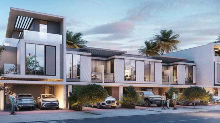 Modern two-story townhouses with balconies, cars in covered driveways, people nearby, and palm trees behind.