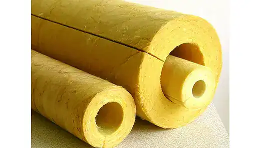 Three yellow cylindrical pipe insulation rolls with hollow centers are arranged on a flat surface.