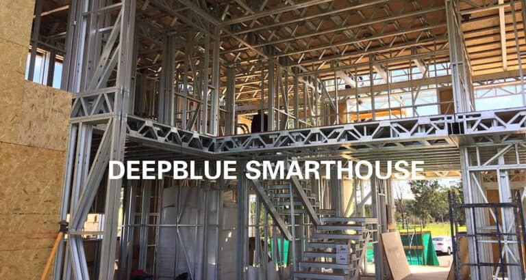 Steel frame building under construction with stairs, labeled "DEEPBLUE SMARTHOUSE.