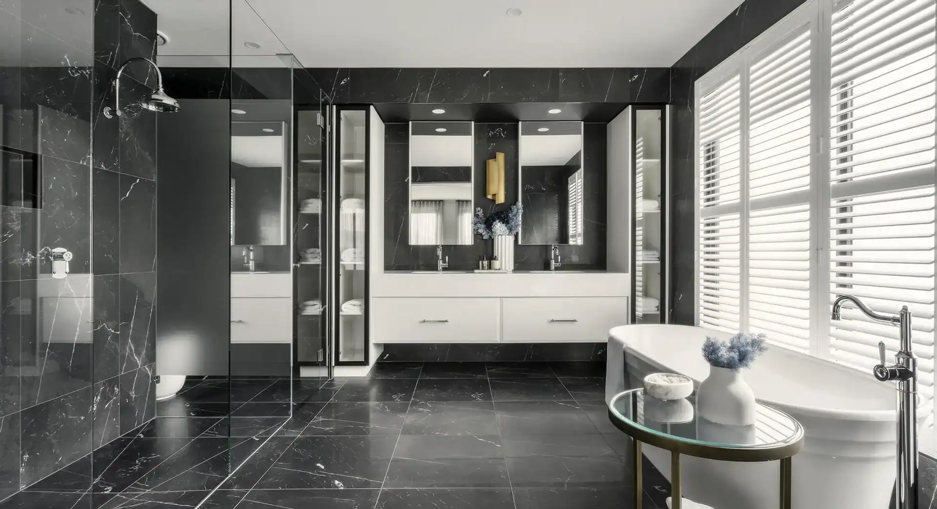 Modern bathroom with black marble, white tub, double vanity, mirrors, and large windows with white blinds.