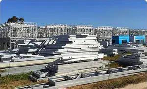 Stacked aluminum construction materials on construction site, building framework in progress, blue sky, industrial project for modern eco-friendly structures.