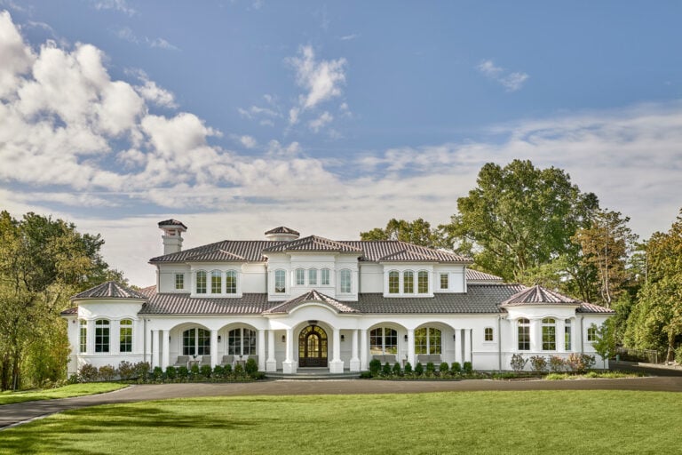 Gorgeous luxury white mansion with Mediterranean architecture, spacious lawn, and lush greenery, showcasing high-end residential design by Deepblue.