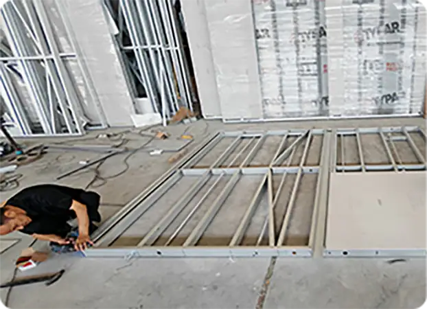Metal framing installation for modular wall system at construction site, building structure for modern interior spaces, sturdy metal framework for drywall or partition walls, commercial construction project, constructing durable interior partitions.