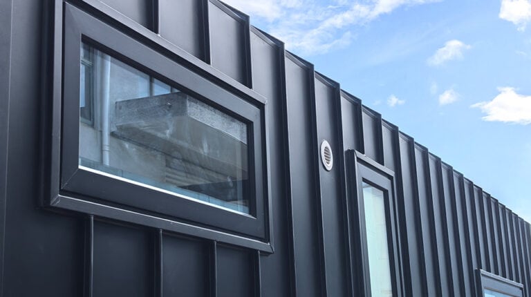 Esterno di un edificio moderno in metallo nero con ampie finestre, che mette in risalto l'elegante design architettonico e la durevolezza, ideale per l'edilizia residenziale e commerciale contemporanea.