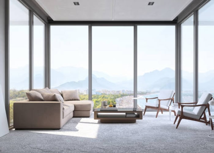 Modern living room with floor-to-ceiling windows showcasing a mountain view, stylish seating, and minimalist decor. Perfect for a luxurious and peaceful home environment.