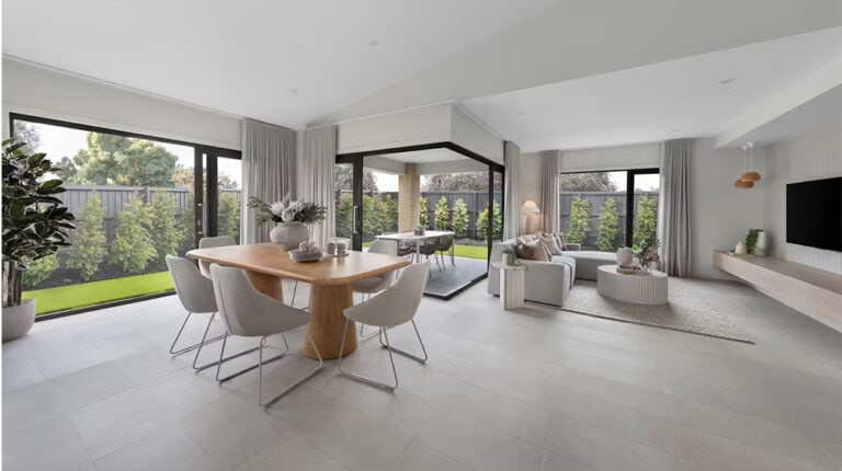 Bright modern open-concept living and dining room with large windows, neutral decor, and lush backyard view, ideal for contemporary home design.