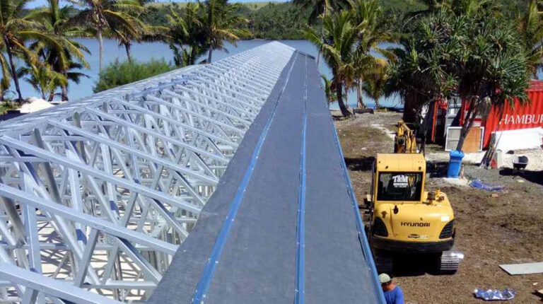 Construction d'un pont-canal en acier inoxydable près d'un front de mer tropical bordé de palmiers, illustrant l'ingénierie moderne et les matériaux durables pour une infrastructure aquatique haut de gamme à Deepblue.