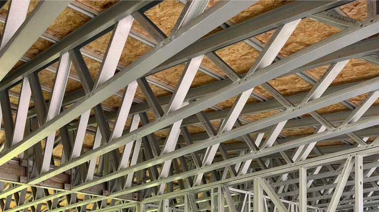 Charpente métallique légère avec platelage en contreplaqué en cours de construction sur un chantier.