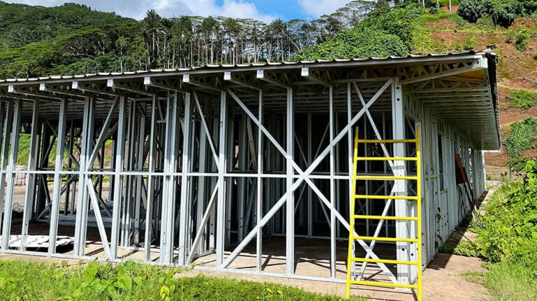 1. Ossature métallique d'une maison sur un chantier de construction avec un paysage verdoyant en arrière-plan, illustrant des matériaux de construction durables et une conception résidentielle moderne.