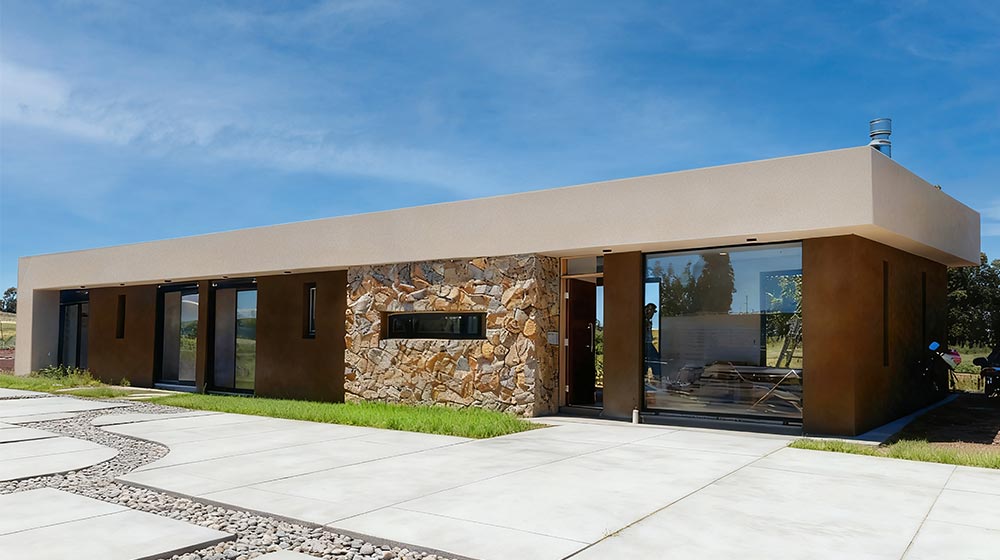 Contemporary modern home with clean lines, large glass windows, and stone accents showcasing sleek architectural design and eco-friendly features.
