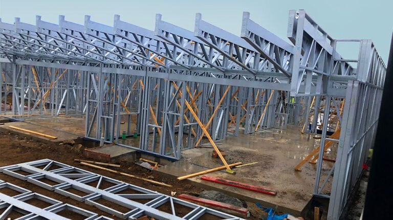 Installation d'une charpente en acier résistant à la corrosion pour un projet de construction moderne réalisé par Deepblue, illustrant des techniques de construction avancées et des matériaux durables pour une intégrité et une longévité supérieures du bâtiment.