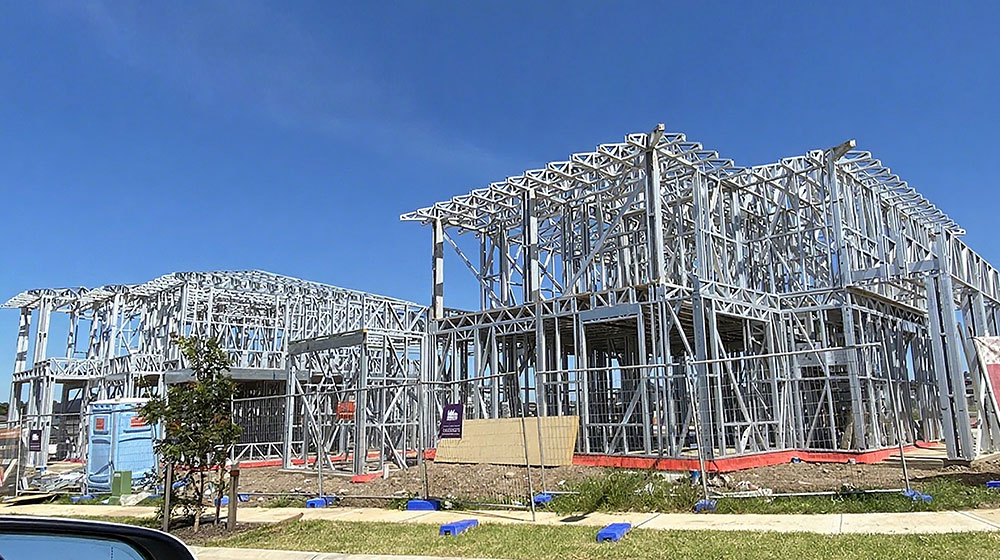 Modern steel-frame construction of a residential building under development, showcasing durable and innovative building materials by Deepblue for sustainable housing solutions.