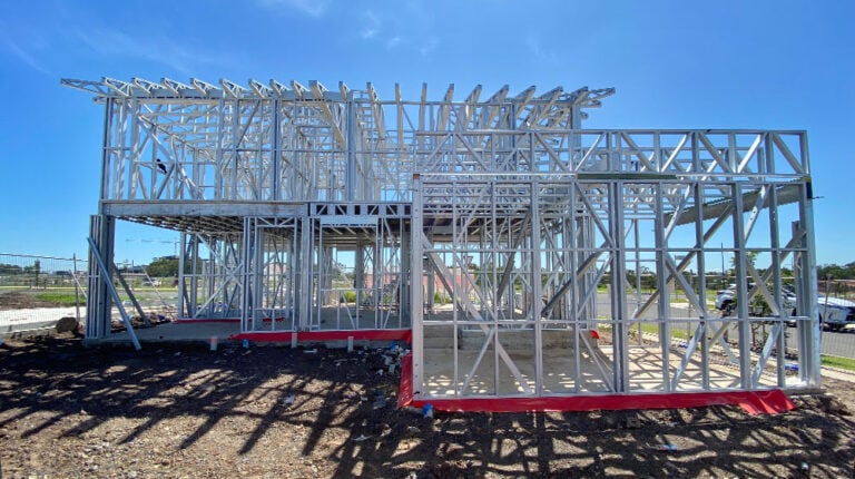 1. Metal house framing under construction with blue sky, showcasing residential steel framing for modern home building.