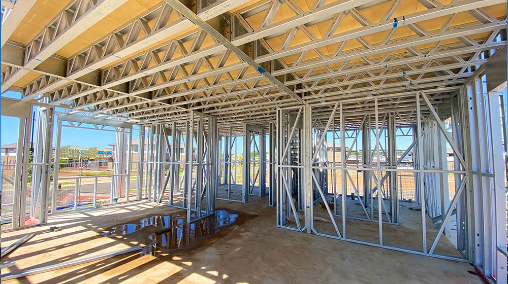 1. Steel framing and wooden roof trusses for new residential home construction under development.