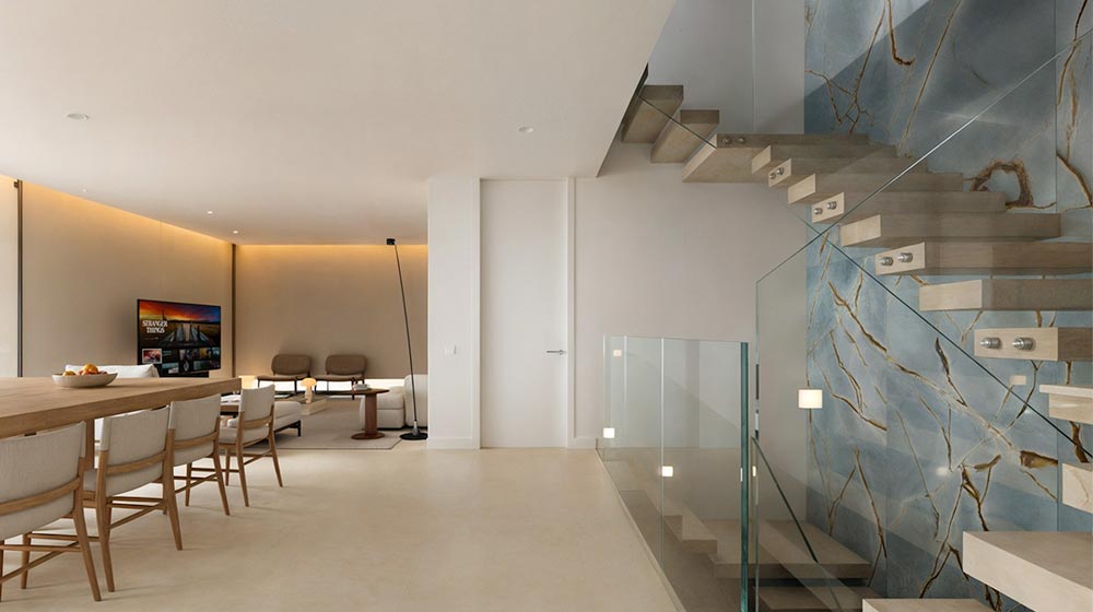 Luxurious modern living room with sleek decor, a staircase featuring marble accents, and minimalist furnishings, creating an elegant and contemporary home interior.