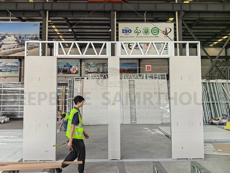 DIY modular building installation in industrial setting, showcasing custom framed wall structure at construction or manufacturing site.