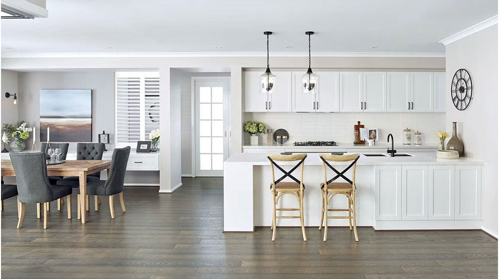 Bright, open-concept kitchen and dining room with white cabinets, modern lighting fixtures, and elegant decor, ideal for stylish and functional living spaces.