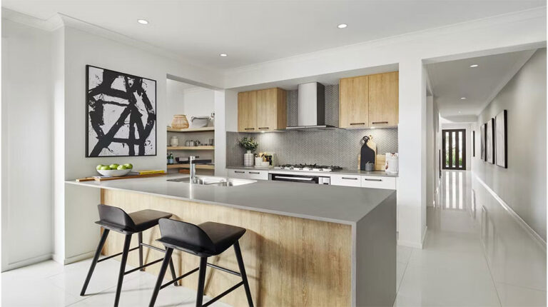 Bright, sleek kitchen with light wood cabinets, gray countertops, and contemporary black bar stools, perfect for a stylish and functional beach house kitchen.