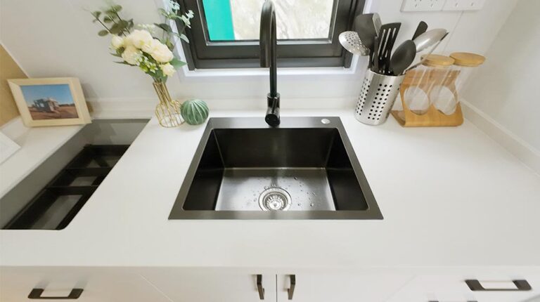 Modern black kitchen sink with sleek design and stainless steel finish in a contemporary kitchen setting.
