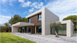Elegant modern house featuring clean lines, large windows, and minimalist style with lush greenery and outdoor seating area.