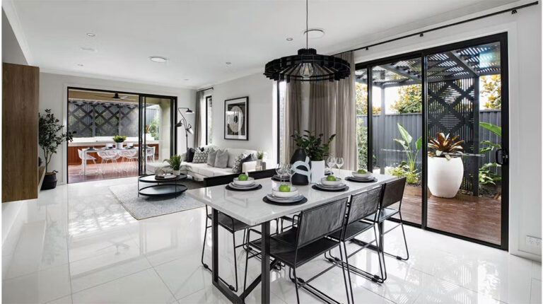 Bright, contemporary living and dining area with sleek decor, large windows, and access to a stylish outdoor patio featuring lush plants and privacy screening, perfect for relaxing and entertaining.