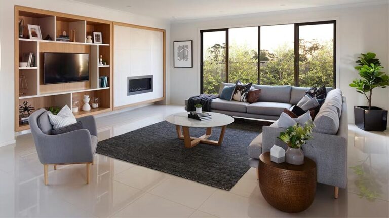 Bright and modern living space with large windows, contemporary furniture, and stylish decor, perfect for relaxing and entertaining. Featuring a sleek fireplace and elegant shelving for a cozy, upscale atmosphere.