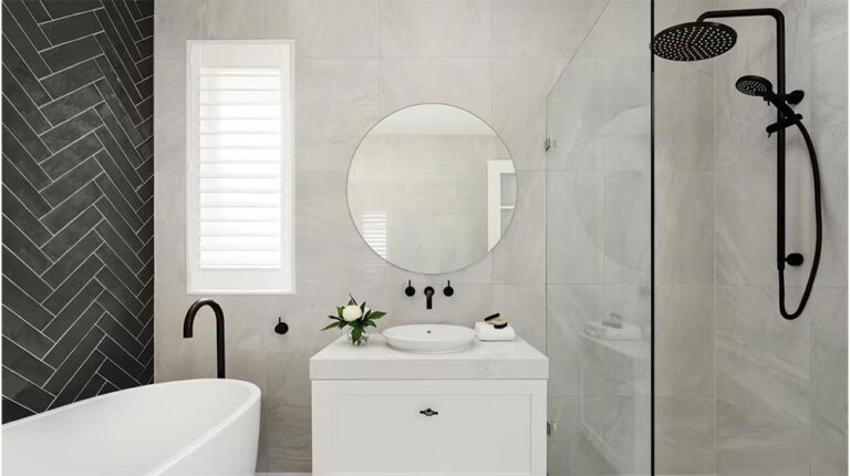 Elegante bagno con elegante soffione doccia nero, rubinetto per lavandino e ganci a parete su pareti in marmo chiaro, con una parete decorativa nera e un arredamento moderno per un look lussuoso.