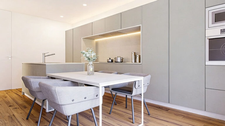 Hedendaagse grijze keuken in minimalistische stijl met strakke kasten en houten vloer, perfect voor een elegant en functioneel interieur.