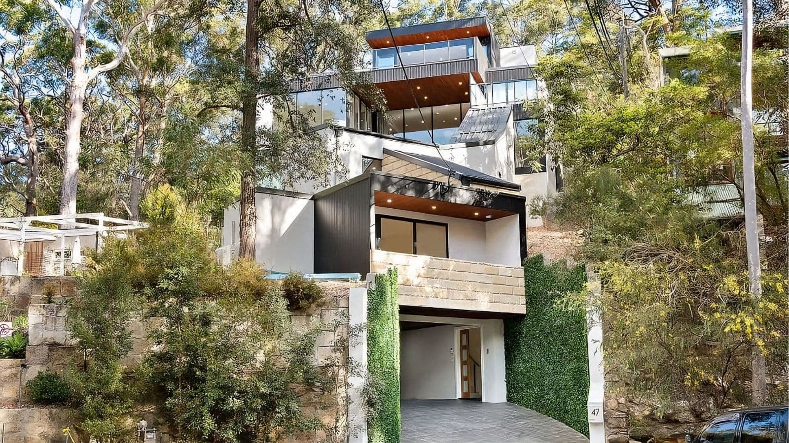 A prefabricated residential home nestled among trees with modern design and natural elements.