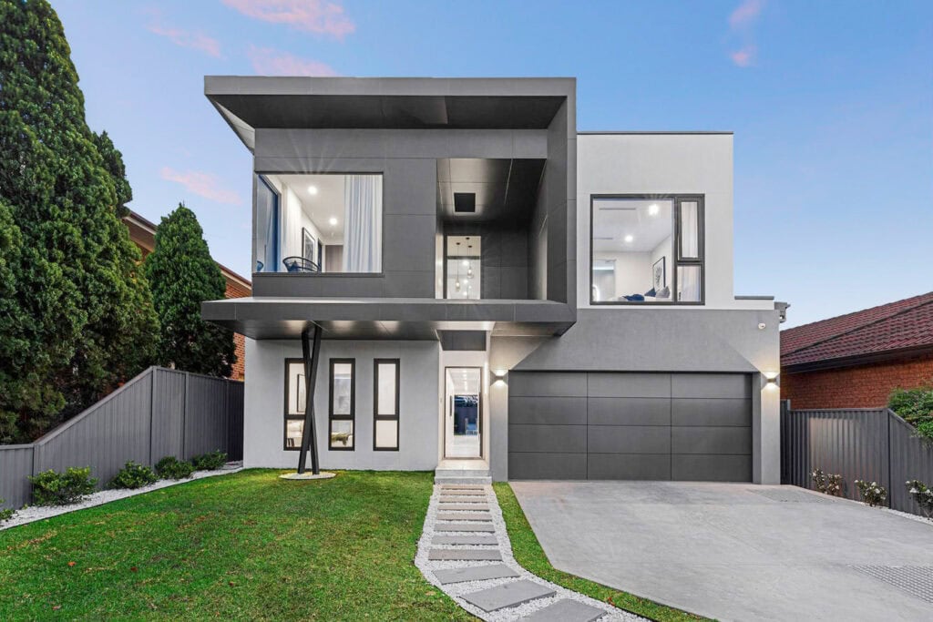 A sleek, modern two-story house with a minimalist design, large windows, and a well-maintained lawn, showcasing contemporary architecture and curb appeal.