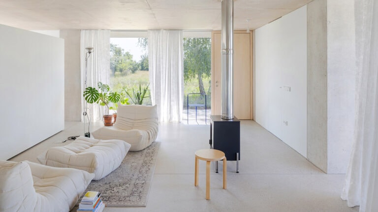 Bright, airy living space featuring large windows, white walls, and minimalist furniture, creating a serene and elegant atmosphere in a Champagne House setting.
