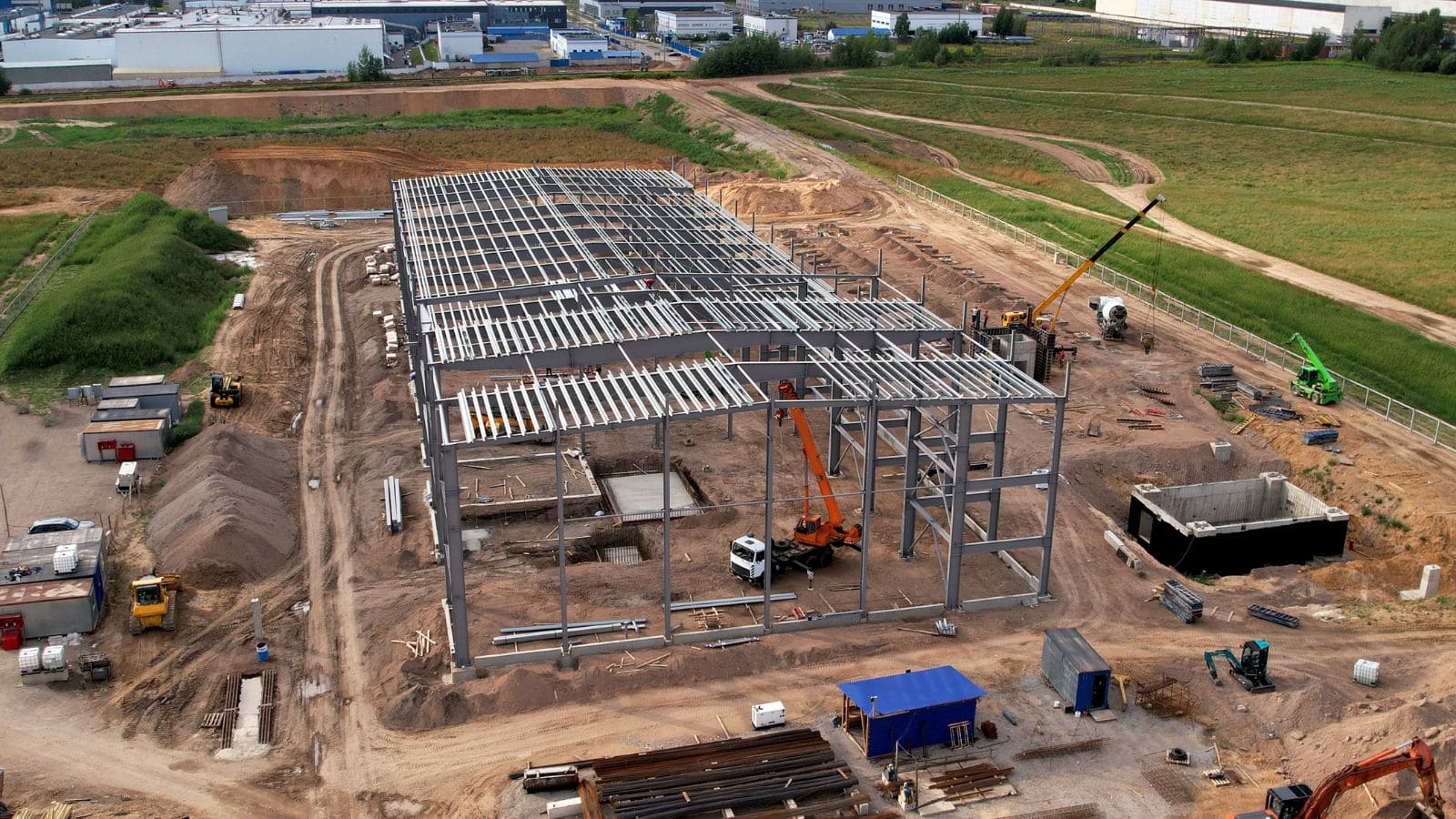 Construction site showing steel framework for a commercial building, highlighting structural steel components and ongoing assembly process.