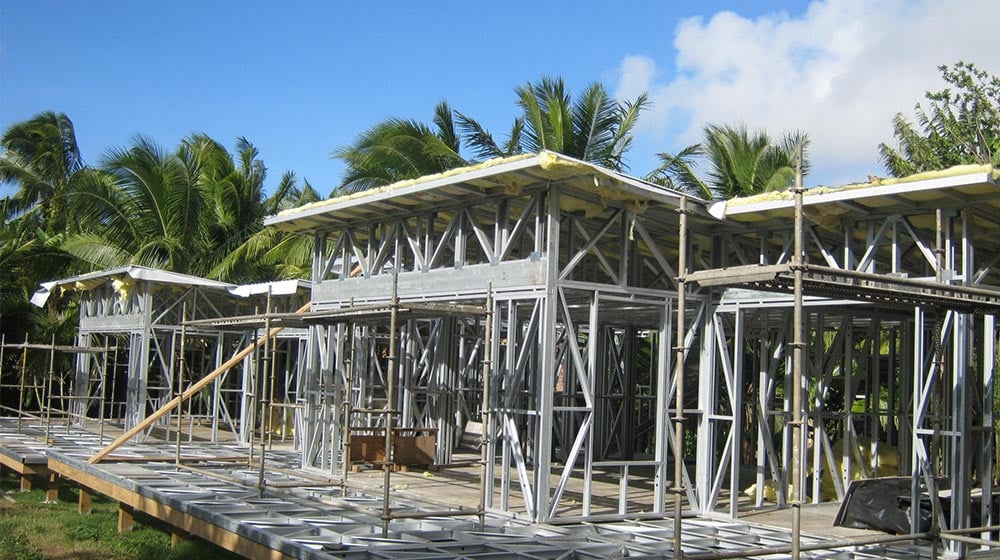 Wooden bungalow framework being built in the Cook Islands, showcasing the advantages of prefab construction with sustainable timber for tropical island living.