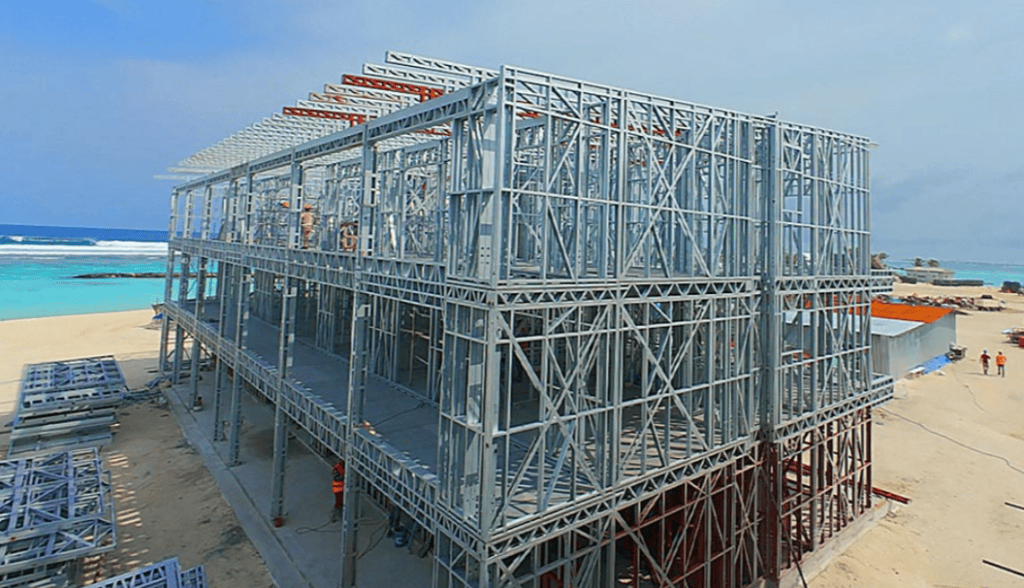 Prefab steel structure under construction on beach site.