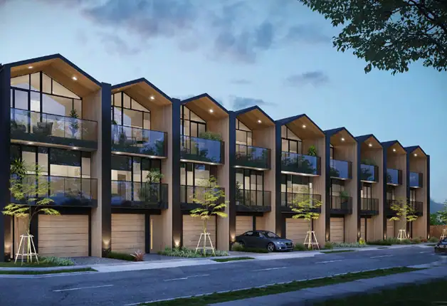 Contemporary multi-family residential building with modern architecture, large glass windows, and balconies, set in a landscaped environment during dusk.