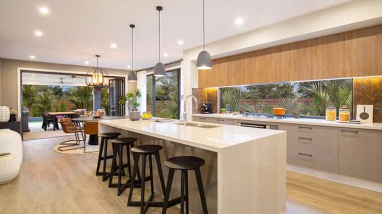 Bright and spacious kitchen in Cairo House featuring a large island, wooden cabinetry, and ample natural light, creating a warm and inviting atmosphere for family living and entertaining.
