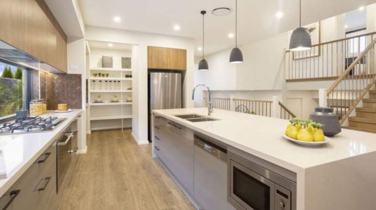 Spacious kitchen in a Cairo house featuring a large island, modern appliances, and ample storage. Bright, airy design with wooden accents and contemporary lighting, perfect for family living and enter.
