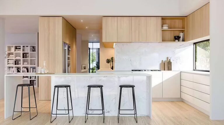 Modern minimalist kitchen featuring a sleek marble island, light wood cabinets, and ample natural light, perfect for contemporary home design and culinary spaces.