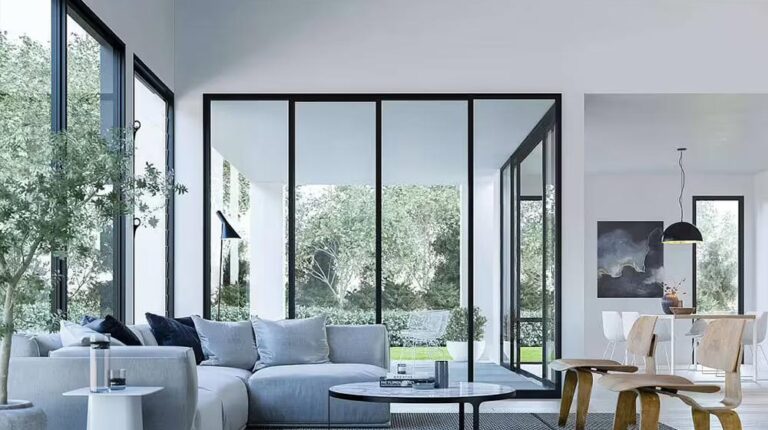 Bright and spacious living room featuring floor-to-ceiling glass windows, contemporary furniture, and a seamless connection to the outdoor greenery, emphasizing modern interior design and natural ligh.
